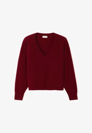 Jersey burdeos con escote en V, mangas largas y bajo recortado. Hecho de tela suave y texturizada. Diseño simple sin patrones ni elementos metálicos.