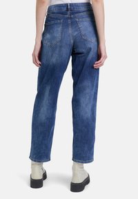 Dunkelblaue Denim-Jeans mit einem entspannten Schnitt, ausgestattet mit zwei Gesäßtaschen und einem geraden Beinausschnitt, umsäumt am Knöchel.