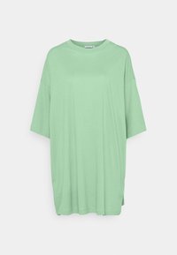 Camiseta de gran tamaño en verde menta con cuello redondo, mangas cortas y un dobladillo trasero ligeramente más largo. Fabricada en suave y ligero tejido de algodón.