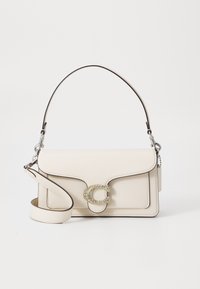 Beige Lederhandtasche mit einem strukturierten Design, einem einzelnen oberen Griff, verstellbarem Tragegurt und einem dekorativen mit Rindsteinen besetzten 'C'-Logo.