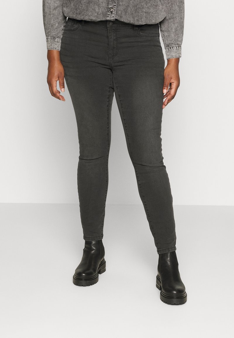 Mörkgrå skinny jeans med en slät textur, med medelhög midja och femficksdesign, i kombination med svarta ankelboots.