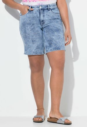 Shorts en denim bleu clair avec des coutures décoratives argentées en motifs de soleil, présentant une taille haute et des poches avant.