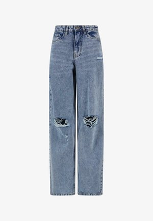 Sinine denimist teksapüksid, millel on suured rebenenud augud mõlemal põlvel ja kerge kulumine paremal reiel.