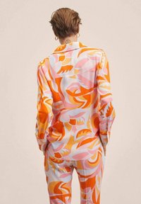 Camicia di seta multicolore con un motivo astratto in arancione, rosa e azzurro; maniche lunghe e design con colletto classico.