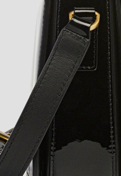 Schwarzer Lacklederhandtaschenriemen mit goldenen Beschlägen, der eine glatte Textur und Nähdetails aufweist, angebracht an einem eleganten Taschenkörper.