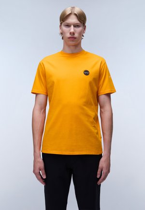 Orange bomulds T-shirt med rund halsudskæring og korte ærmer; har et lille sort rundt logo på venstre bryst.