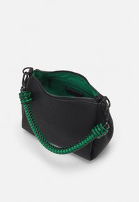 Sort læder håndtaske med en grøn flettet rem og lynlås lukning. Indvendigt har den en klar grøn foring og en lomme. Tekstureret ydre.