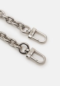 Una catena in acciaio inossidabile caratterizzata da grandi maglie interconnesse e due fermagli a clip, che mostra una finitura lucida e brillante.