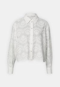 Chemise blanche raccourcie avec des motifs paisley brodés, dotée d'une fermeture à boutons à l'avant et de manches longues avec des détails en dentelle.