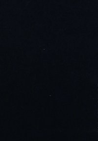 Črna teksturirana površina z majhnimi, raztresenimi belimi in oranžnimi pikami. Na splošno temna in enotna ozadje z subtilnimi premazi.