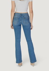 Jeans a gamba larga in denim azzurro chiaro con vita media. Presentano cinque tasche e una cucitura sottile sul retro, progettati per un look aderente.
