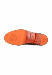 Schoenzool met een zwarte buitenlaag, een oranje tussenzool en reliëfbranding. Gladde textuur met een lichte kromming aan de teen.