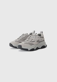 Grey sneakers featuring a mix of suede and mesh materials, rounded toe, textured sole, and rear pull tab for easy wear.