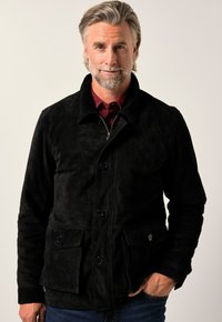 Svart mockajacka med knappstängning framtill, dold dragkedja, två bröstfickor och krage, med en slät yta.