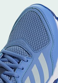 Modré atletické tenisky s vrchnou časťou z sieťoviny, textúrovanými syntetickými prekrytiami, tromi bielymi pruhmi a kontrastnými šnúrkami a detailami na podrážke.