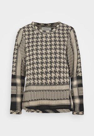 Pitkähihainen pyöreäkauluksinen paita, jossa on mustia ja beigejä tikkaus-, kalanruoto- ja ruutukuvioita, jotka muodostavat tikkaustyylisen kuosin.