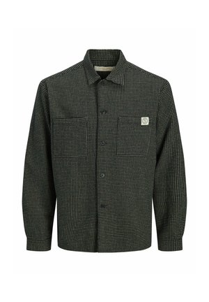 Chemise à manches longues à carreaux vert foncé et blanc avec deux poches avant et un petit patch logo blanc sur la poche gauche.
