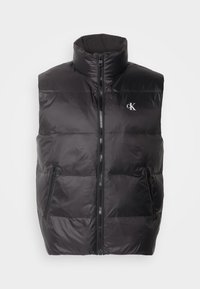Gilet nero imbottito con colletto alto, zipper frontale e due tasche laterali. Presenta pannelli cuciti e un logo sul petto.