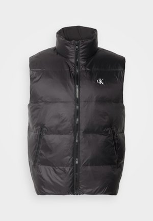 Gilet en duvet noir avec col haut, fermeture éclair frontale et deux poches latérales. Présente des panneaux cousus et un logo sur la poitrine.