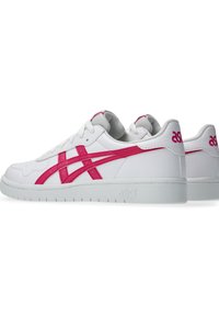 Białe buty sportowe z różowymi akcentami. Gładka skórzana cholewa, niski krój, perforowane detale oraz gumowa podeszwa z teksturowanym gripem.