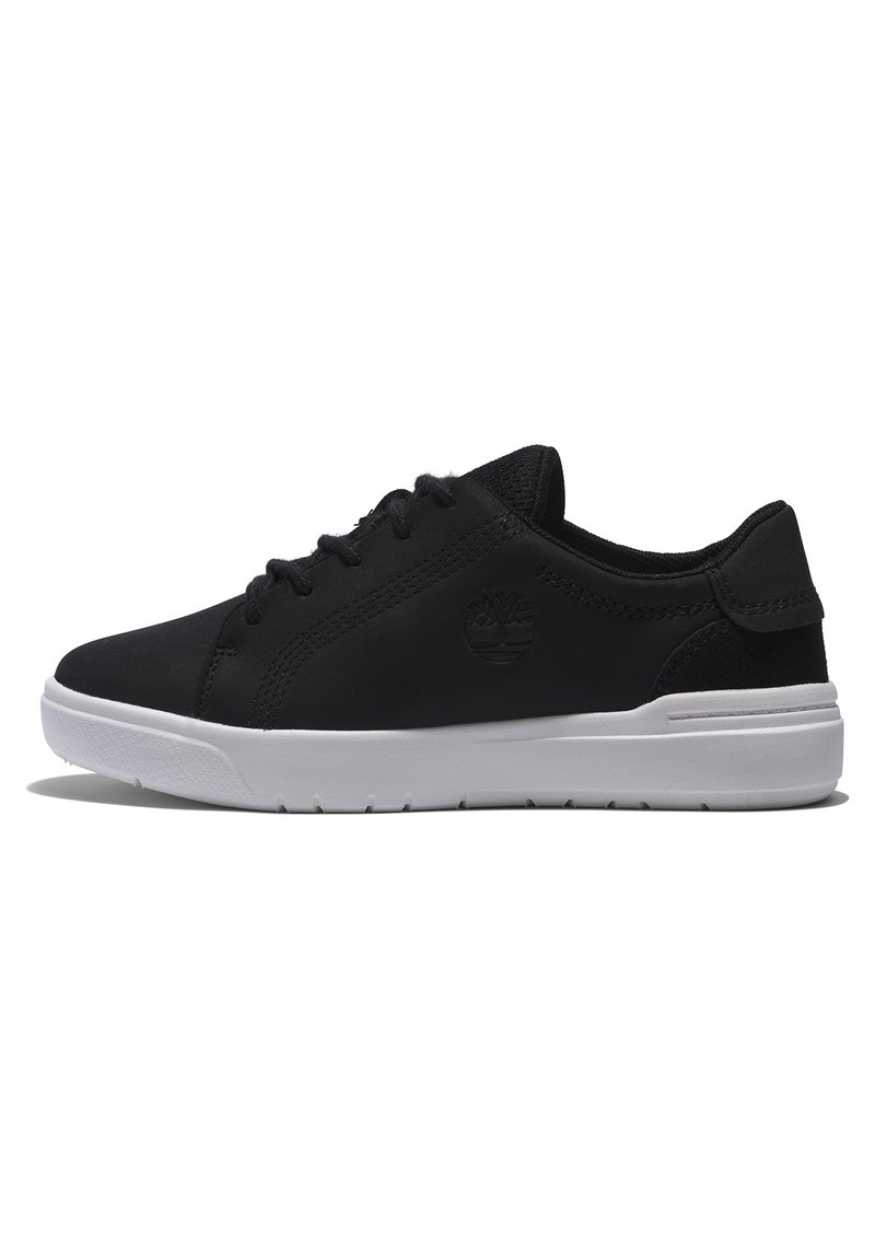 Black sneaker with a smooth upper, featuring a logo, white sole, and lace-up design; texture appears soft and durable.