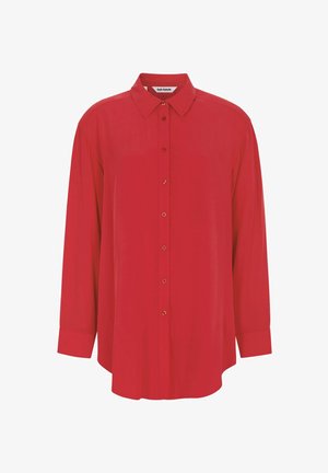 Sarkana garo piedurkņu krekls ar pogu izgriezumu, apkakli un zelta krāsas pogām. Izgatavots no viegla auduma, ar brīvu piegriezumu un noapaļotu apakšu.