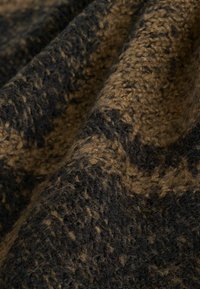 Tessuto intrecciato in tonalità terra bruna e nera con una superficie testurizzata e pelosa. Presenta un motivo di fibre che si intrecciano.