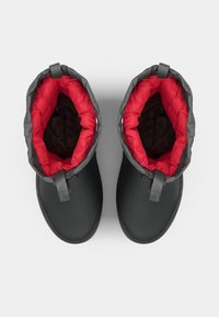Botas impermeables negras con un forro acolchado rojo extraíble, que presentan un puño gris, cordones exteriores y una suela texturizada para mayor agarre.