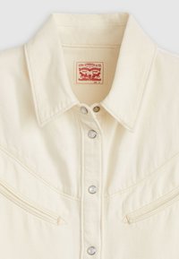 Camicia in denim crema di Levi's con colletto a punta, due tasche sul petto, bottoni a pressione argento e cuciture distintive dello scollo in stile western.