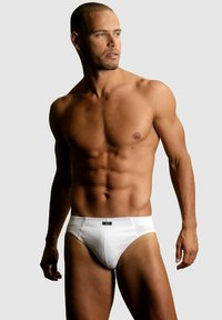 Weiße Herrenunterhose mit enganliegendem Schnitt, hergestellt aus glattem Stoff. Verfügt über ein einfaches Design, einen tief sitzenden Bund und ein kontrastierendes Etikett auf der Vorderseite.