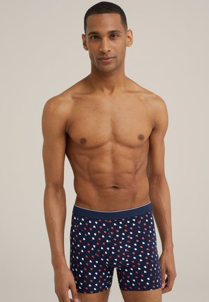 Boxer shorts azul marino con un patrón geométrico en rojo y blanco, que cuentan con una cinturilla elástica y un diseño ajustado. Material de algodón suave.