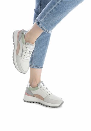 Zapatillas blancas con acentos en verde y rosa, materiales de cuero texturizado y gamuza, que cuentan con cordones, un zipper lateral y una suela de goma gruesa.