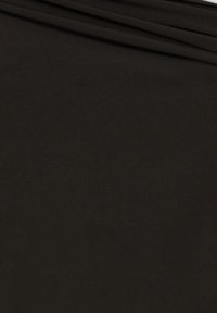 Tessuto nero con una consistenza liscia e opaca, caratterizzato da una leggera lucentezza. Piegato, mostrando delle morbide pieghe e un aspetto uniforme e coerente.