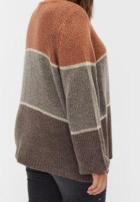 Suéter de punto con un diseño a rayas en óxido, gris y marrón oscuro. Tiene un corte relajado, con puños acanalados y una textura suave.