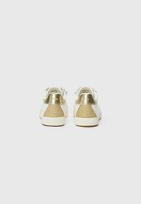Sneakers bianchi con accenti metallici dorati e una sezione del tallone in glitter dorato testurizzato, caratterizzati da una finitura liscia e chiusura con lacci.