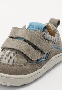 Sølvfarget lær og nettingtoddler sko med blå detaljer, som har to borrelåser, en polstret krage og en gummisåle.