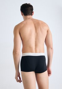 Zwarte boxershorts met een zachte elastische tailleband met het "Calvin Klein" logo in lichtgrijs. Gladde stof, strakke pasvorm en minimale details.
