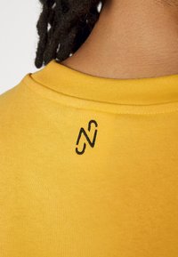 Puma NJR TEE - T-shirts med print - mimosa