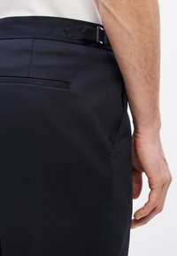 Παντελόνι ναυτικού μπλε με υφή υφάσματος, διαθέτει θηλιά ζώνης, μία πίσω τσέπη και καθαρές πλαϊνές ραφές. Λείο φινίρισμα και μοντέρνο κόψιμο.