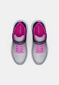 Hallid hallid spordijalatsid roosa aktsendi ja kummipaeltega, millel on tekstuuriga disain ning must rihm ees. Muudetav kaubamärk on selgelt nähtav.