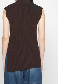 Brauner, gerippter ärmelloser Pullover mit hohem Kragen. Das Design zeichnet sich durch einen längeren hinteren Saum und eine strukturierte Oberfläche aus.