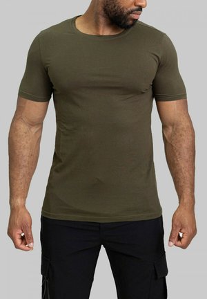 T-shirt ajusté olive en coton mélangé à manches courtes, avec un col rond et une texture lisse, porté avec un pantalon cargo noir.