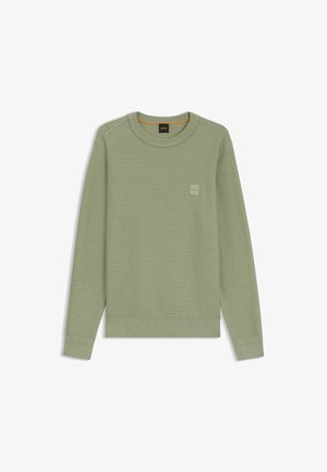 Groene gebreide trui met een getextureerde afwerking, ronde halslijn en een subtiele logopatch op de borst. Ribgebreide manchetten en boord.