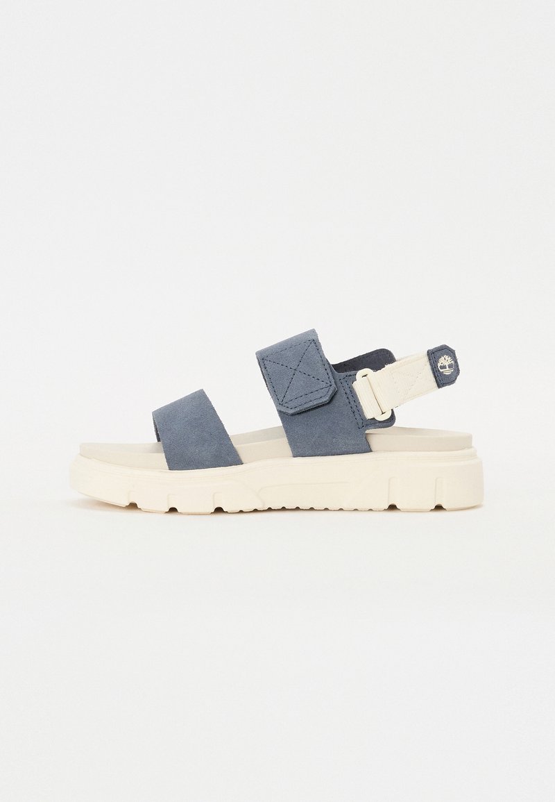 Mėlyni sušvelninto suede sandalai su dviem dirželiais ir reguliuojamu nugara. Storas grietinėlės spalvos guminis padas su tekstūruotais akcentais ir logotipo detalėmis.