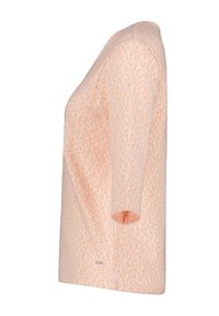 Perzikkleurig T-shirt met korte mouwen en een gestructureerd, patroonontwerp. Het materiaal lijkt zacht; het heeft een relaxte pasvorm en een ronde hals.