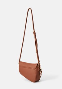 Sac bandoulière en cuir marron texturé avec un rabat, une sangle réglable et des détails en métal doré. Forme élégante et compacte.