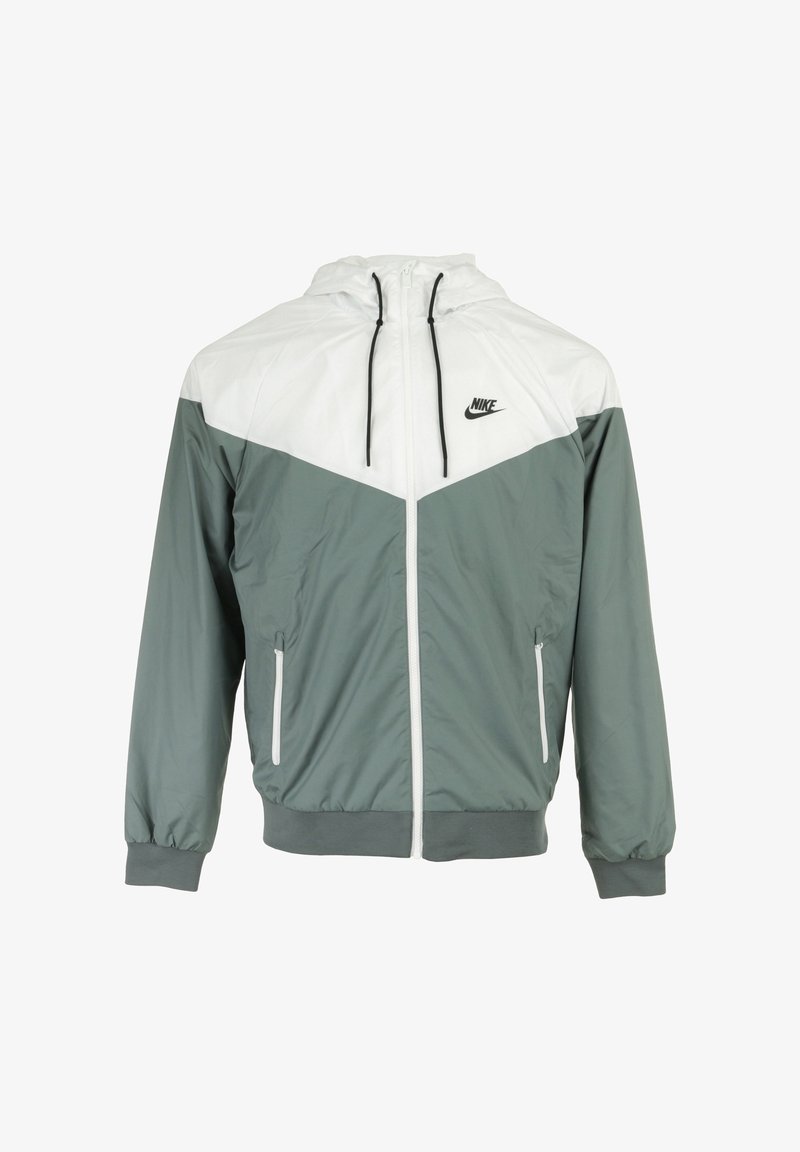 Nike windbreaker jack in lichtgrijs en groen. Bevat een capuchon, ritssluiting aan de voorkant, zijzakken, elastische manchetten en een geometrisch kleurblokontwerp.