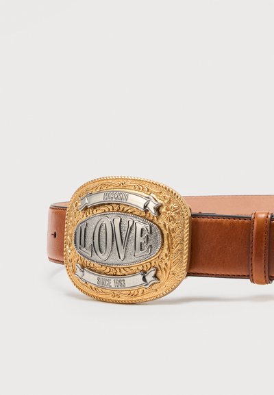 Καφέ δερμάτινη ζώνη με μεγάλο περίτεχνο χρυσό και ασημένιο αγκράφα, χαραγμένη με "LOVE," "MOSCHINO," και "SINCE 1983."