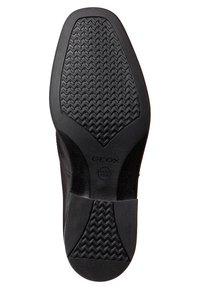Black rubber shoe sole with a zigzag tread pattern, featuring "GEOX" branding and circular logo. Smooth texture with a solid construction.