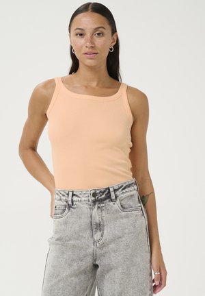 Perzik ribgebreide tanktop met brede schouderbanden en vierkante halslijn, gecombineerd met hooggerokte acid-wash denim jeans. Heeft een strak ontwerp en textuur.
